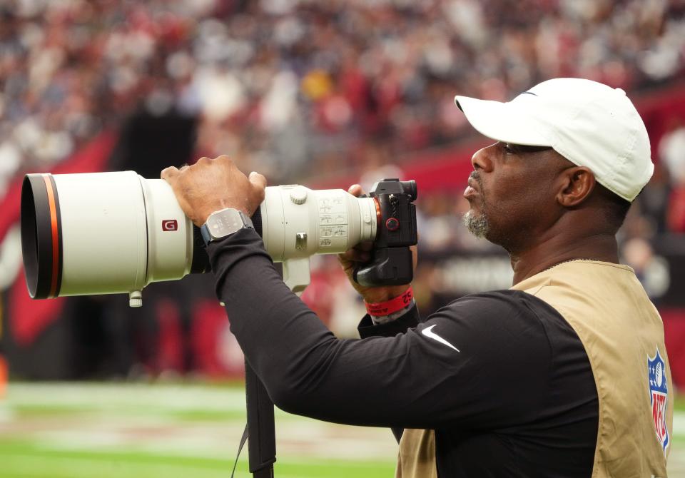 Former baseball great Ken Griffey Jr. takes photos on the sidelines as the Arizona Cardinals play the Dallas Cowboys at State Farm Stadium in Glendale on Set. 24, 2023.