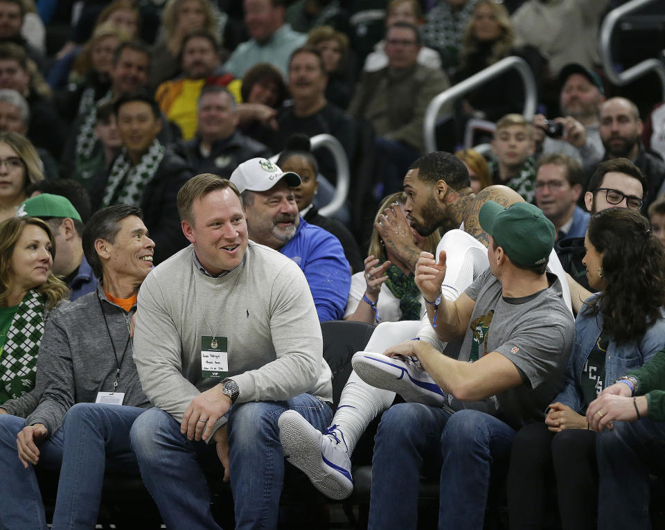 Philadelphia 76ers' Mike Scott takes a sip of a fan's drink after diving into the stands for the ball during the first half of an NBA basketball game against the Milwaukee Bucks, Sunday, March 17, 2019, in Milwaukee. (AP Photo/Aaron Gash)