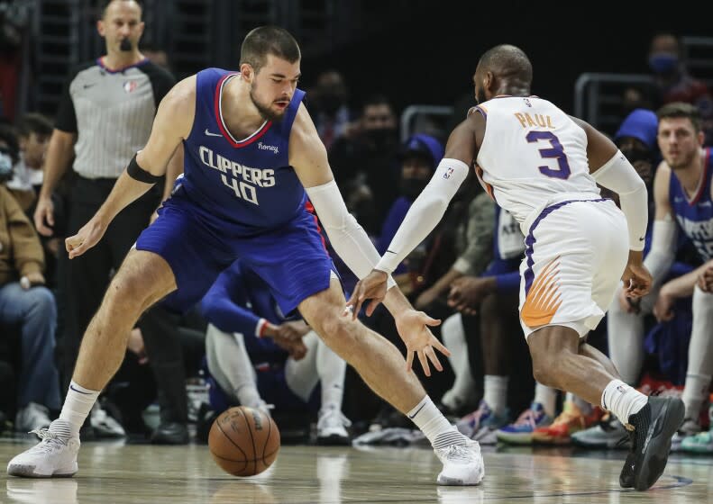 Los Angeles, CA, Monday, December 13, 2021 - Phoenix Suns guard Chris Paul (3) dribbles the ball between the legs of LA Clippers center Ivica Zubac (40) during first half action at Staples Center. (Robert Gauthier/Los Angeles Times)