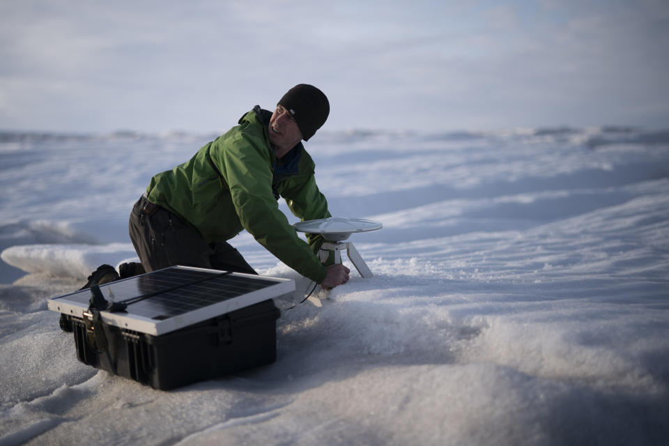 In this Aug. 16, 2019, photo, Brian Rougeux, NYU Field Safety Officer, installs a GPS antenna at the Helheim glacier, in Greenland. An NYU team is tracking what's happening in Greenland from both above and below. The head of the New York University team, air and ocean scientist David Holland, calls Greenland "the end of the planet" referring to geography more than the future. Yet in many ways Greenland is where the planet's warmer and watery future is being written. (AP Photo/Felipe Dana)