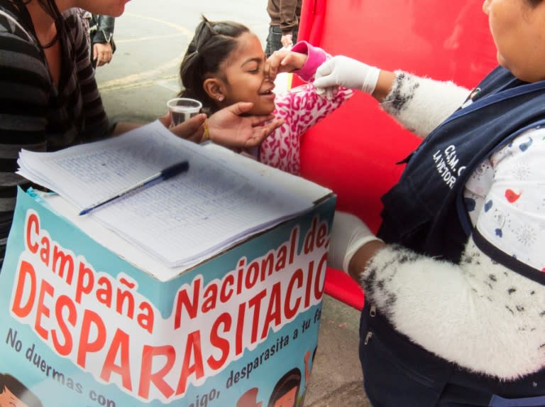 A Peruvian girl receives a deworming medicine at a street health post in Lima on September 30, 2018, as part of a national prevention campaign against anemia and chronic malnutrition