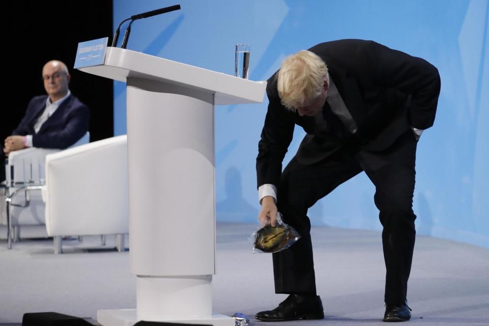 Boris Johnson picks up the kipper fish as he addresses Tory members (AFP/Getty Images)