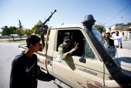 A Turkey-backed Syrian rebel fighter reacts before crossing into Syria, in the border town of Akcakale