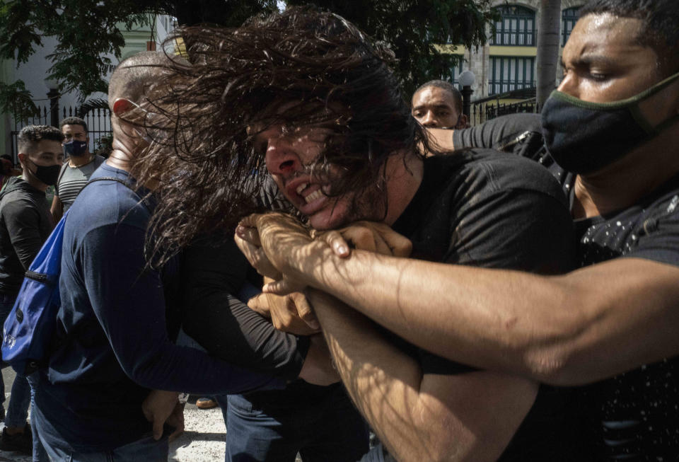 Plainclothes police detain an anti-government protester during a protest in Havana, Cuba, Sunday, July 11, 2021. Hundreds of demonstrators went out to the streets in several cities in Cuba to protest against ongoing food shortages and high prices of foodstuffs, amid the new coronavirus crisis. (AP Photo/Ramon Espinosa)