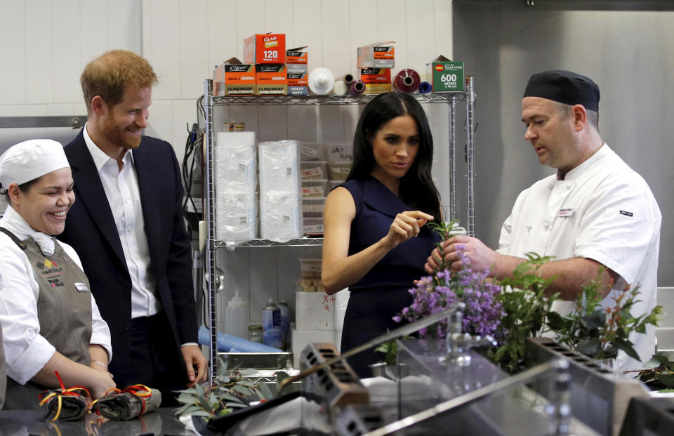 Britain's Prince Harry and his wife, Meghan, Duchess of Sussex, look at traditional native Australian ingredients during a visit to Mission Australia social enterprise restaurant, Charcoal Lane, in Melbourne, Australia, Thursday, Oct. 18, 2018. Prince Harry and his wife Meghan are on day three of their 16-day tour of Australia and the South Pacific. (Phil Noble/Pool Photo via AP)