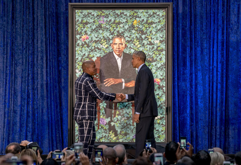 Former President Barack Obama, right, and Artist Kehinde Wiley, left, shake hands as they unveil Obama’s official portrait at the Smithsonian’s National Portrait Gallery, Monday, Feb. 12, 2018, in Washington. (AP Photo/Andrew Harnik)