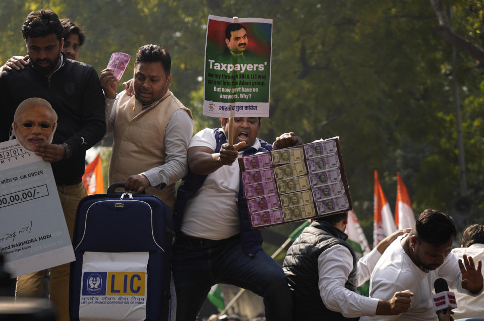 Members of opposition Congress party, demanding an investigation into allegations of fraud and stock manipulation by India's Adani Group shout slogans atop a police barricade during a protest in New Delhi, India, Monday, Feb.6, 2023. The Congress party urged people to protest, adding to pressure on Prime Minister Narendra Modi to respond to a massive sell-off of shares in Adani Group companies after a U.S.-based short-selling firm, Hindenburg Research, accused them of various fraudulent practices. The Adani group has denied any wrongdoing. (AP Photo/Manish Swarup)