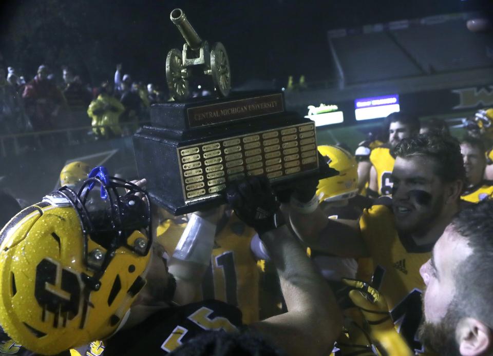 Central Michigan football players hold the Victory Cannon trophy after their NCAA college football game against Western Michigan, Wednesday, Nov. 1, 2017, in Kalamazoo, Mich. The Victory Cannon is awarded to the winner of the in-state rivalry. (AP Photo/Carlos Osorio)