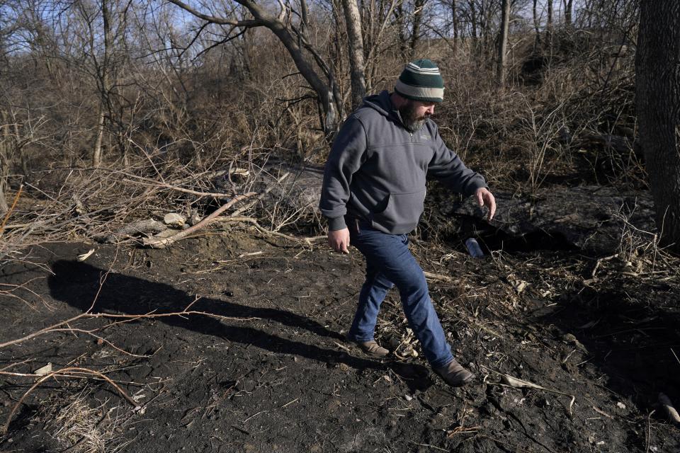 Nick Helland walks near a bioreactor system outflow pipe draining in a nearby stream, Thursday, March 2, 2023, near Slater, Iowa. Simple systems called bioreactors and streamside buffers help filter nitrates from rainwater before it can reach streams and rivers. (AP Photo/Charlie Neibergall)