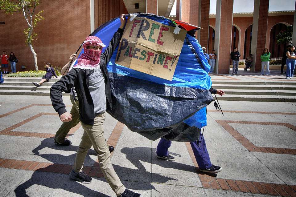 FILE - University of Southern California protesters carry a tent around Alumni Park on the University of Southern California to keep security from removing it during a pro-Palestinian occupation, Wednesday, April 24, 2024, in Los Angeles. (AP Photo/Richard Vogel, File)