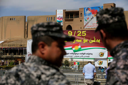 Kurdish policemen look on towards banners supporting the referendum for independence of Kurdistan in Erbil, Iraq September 24, 2017. REUTERS/Alaa Al-Marjani