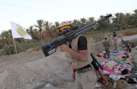 A Shi'ite fighter carries his weapon during a patrol in Jurf al-Sakhar October 25, 2014. REUTERS/Stringer