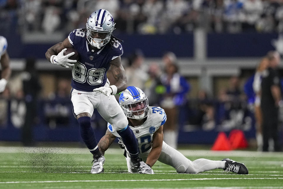 Dallas Cowboys wide receiver CeeDee Lamb (88) runs with the ball as Detroit Lions safety Brian Branch (32) tries to stop him during the second half of an NFL football game, Saturday, Dec. 30, 2023, in Arlington, Texas. (AP Photo/Sam Hodde)