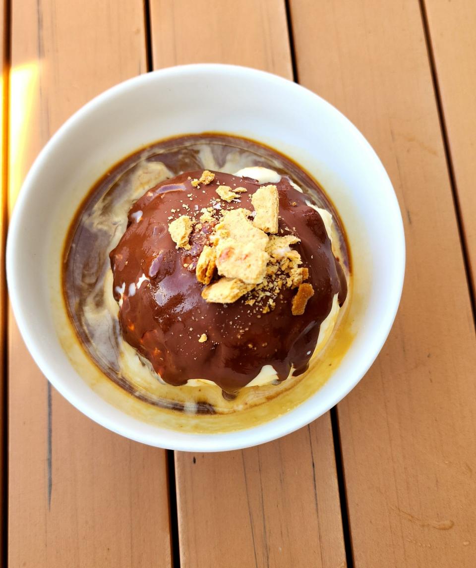 The Fluff-O-Gato dessert served at Giusto is an elevated take on a affogato. The ice cream is graham cracker gelato, coated in a roasted marshmallow swirl and a chocolate shell.