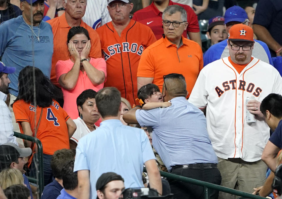 A young child is carried from the stands after being injured by a foul ball off the bat of Chicago Cubs' Albert Almora Jr. during the fourth inning of a baseball game against the Houston Astros Wednesday, May 29, 2019, in Houston. (AP Photo/David J. Phillip)