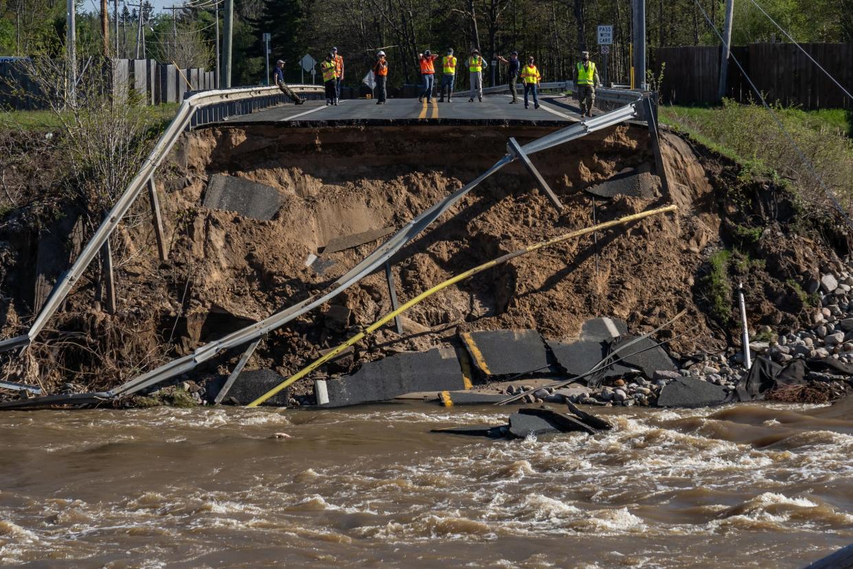 Workers look over a washed out bridge after the Edenville Dam collapsed above Wixom Lake, near Midland, Michigan in May 2020, when heavy rains flooded the area. Six of Michigan's 10 wettest years in history have occurred since 2006, and 2019 was the state's wettest year on record.