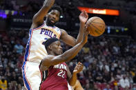 Miami Heat forward Jimmy Butler (22) passes the ball as Philadelphia 76ers center Joel Embiid defends during the second half of an NBA basketball game, Saturday, Jan. 15, 2022, in Miami. (AP Photo/Lynne Sladky)