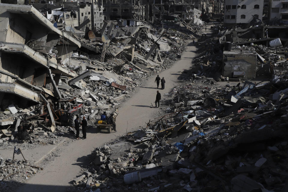 Palestinians walk through the destruction from the Israeli offensive in Jabaliya refugee camp in the Gaza Strip on Thursday, Feb. 29, 2024. (AP Photo/Mahmoud Essa)