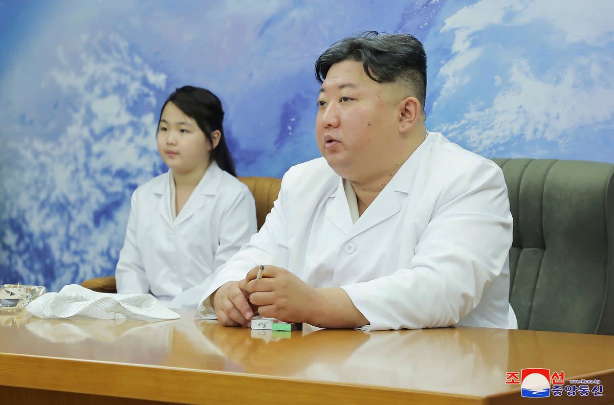 North Korean leader Kim Jong-un, right, and his daughter, Kim Ju-ae, visit the country's aerospace agency on Tuesday  (AP)
