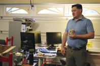 Elliot Dale stands in his garage that he turned into a home office in Lake Oswego, Ore., Oct. 30, 2020. While the space is cramped, Dale says it provides him a quiet space to work as his three children take their online school classes inside of their home. In Oregon, one of only a handful of states that has required a partial or statewide closure of schools in the midst of the COVID-19 pandemic, parents in favor of their children returning to in-person learning have voiced their concerns and grievances using social media, petitions, letters to state officials, emotional testimonies at virtual school board meetings and on the steps of the state's Capitol. (AP Photo/Sara Cline)