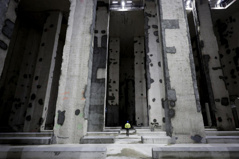 A man walks in the Austerlitz wastewater and rainwater storage basin, which is intended to make the Seine river swimmable during the Paris 2024 Olympic Games, in Paris, during its inauguration Thursday, May 2, 2024. The works underground next to Paris' Austerlitz train station are part of a 1.5 billion euro effort to clean up the Seine so it can host marathon swimming and triathlon events at the July 26-Aug 11 Summer Games and be opened to the general public for swimming from 2025. (Stephane de Sakutin, Pool via AP)