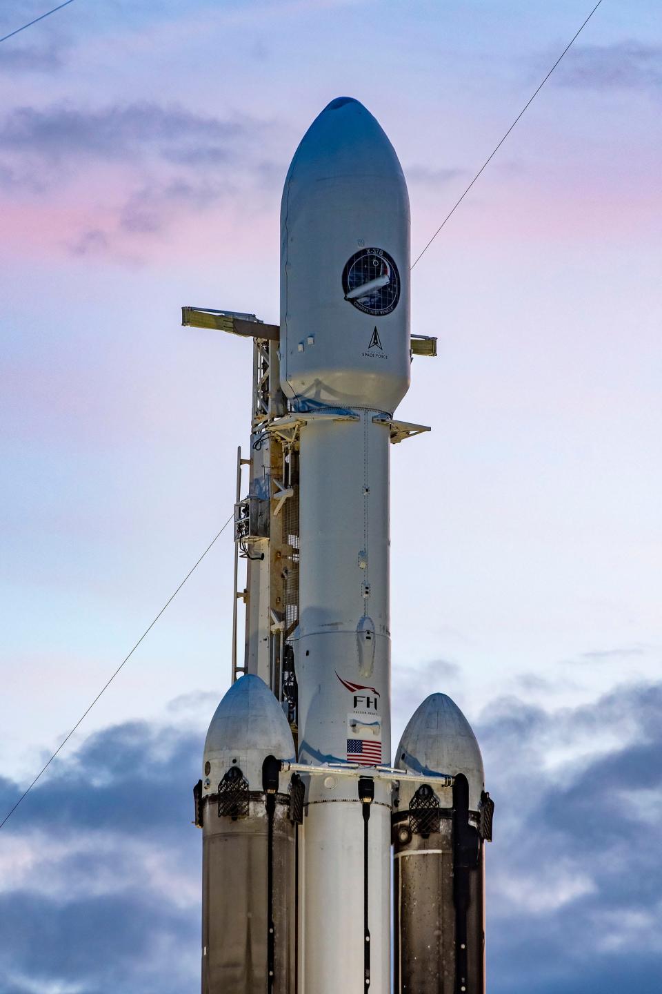 A SpaceX Falcon Heavy rocket carrying the Space Force X-37B robotic orbital plane stands at pad 39A at sunset Saturday at NASA's Kennedy Space Center.