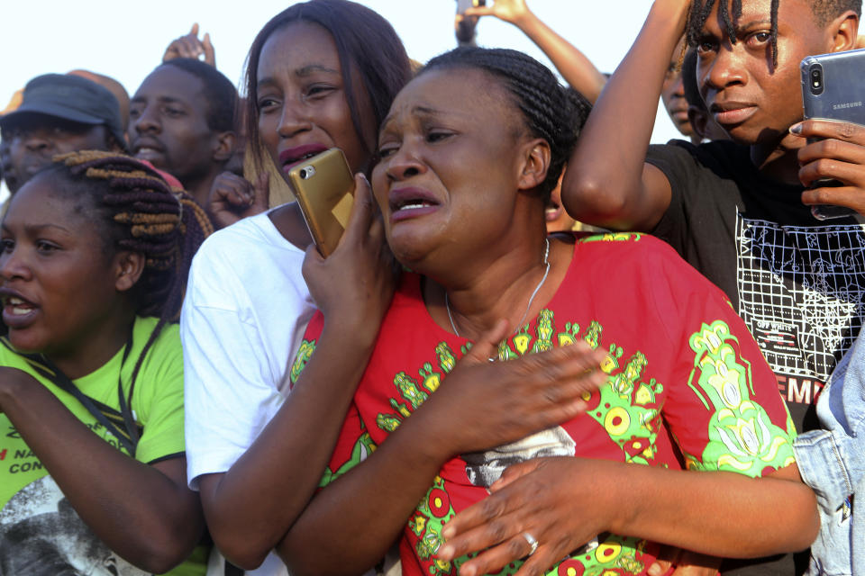 Supporters of Zimbabwe's former ruler, Robert Mugabe react upon the arrival of his remains at at RG Mugabe airport in Harare,Wednesday, Sept, 11, 2019.(AP Photo/Tsvangirayi Mukwazhi)