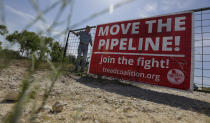 Andy Sansom closes the gate to his property where a proposed new natural gas pipeline would pass through his ranch in the Texas Hill Country near Stonewall, Texas Friday, Aug. 2, 2019. A proposed pipeline is a 430-mile, $2 billion natural gas expressway that pipeline giant Kinder Morgan has mapped from the booming West Texas oil patch to Houston. (AP Photo/Eric Gay)