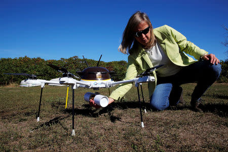 Helen Greiner, founder of CyPhy Works, catches a UPS package carried by a CyPhy Works drone to Children's Island off the coast of Beverly, Massachusetts. REUTERS/Brian Snyder