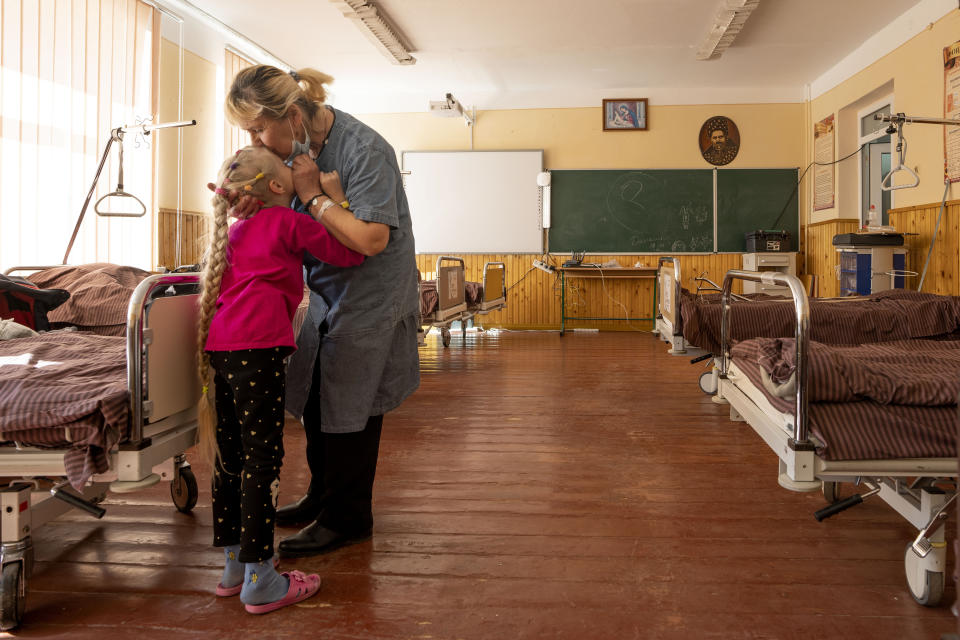 Nadia kisses her 10-year-old granddaughter Zlata Moiseinko, suffering from a chronic heart condition, as she receives treatment at a schoolhouse that has been converted into a field hospital in Mostyska, western Ukraine, Thursday, March 24, 2022. The United Nations children’s agency says Russia’s invasion has displaced half of Ukraine’s children, one of the largest such displacements since World War II. (AP Photo/Nariman El-Mofty)