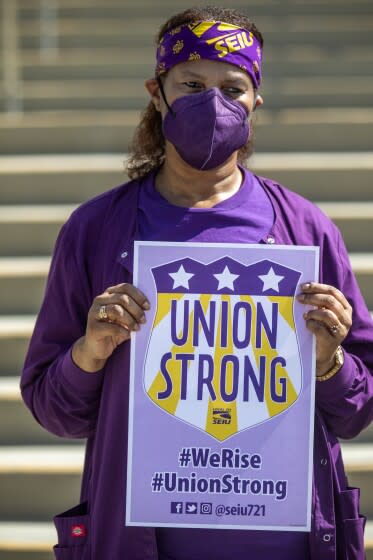 LOS ANGELES, CA - MAY 26: Public Health Nurse Markeitha Harris holds a SEIU Local 721 sign during a press conference outside LAC+USC Medical Center Thursday, May 26, 2022, in Los Angeles, CA. SEIU Local 721 president David Green said all 22 units, including 3 nursing groups heading toward a strike, have agreed to a new contract with LA County. That means nurses, social workers, custodians & others consisting of 55,000 workers have reached an agreement. (Francine Orr / Los Angeles Times)