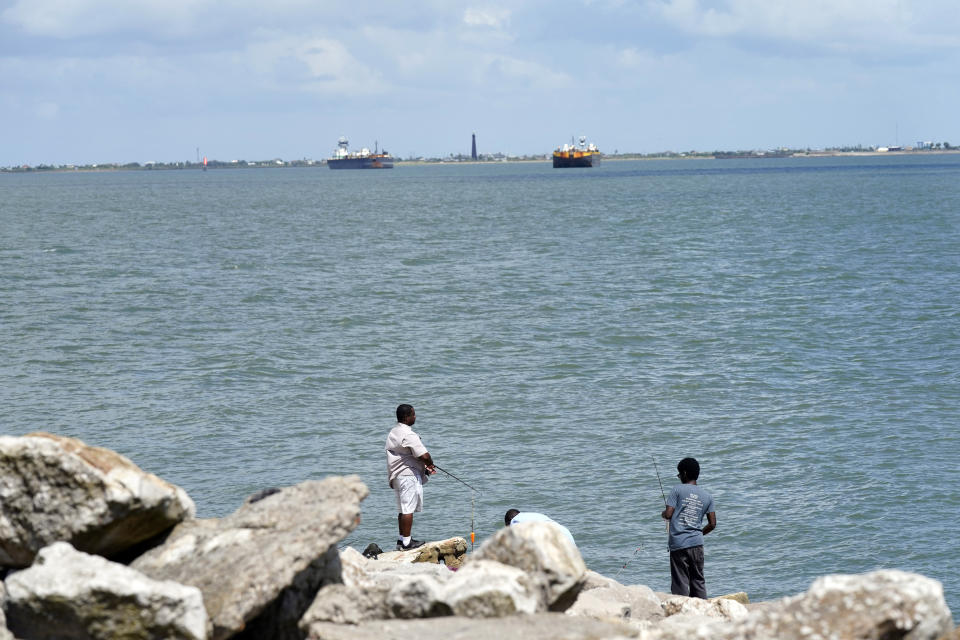 People fish in Galveston Bay Friday, Sept. 4, 2020, in Galveston, Texas. The Ike Dike is a proposed coastal barrier that would protect the Houston-Galveston region, including Galveston Bay from hurricane storm surge. The project was conceived by Bill Merrell, a professor in the Marine Sciences Department at Texas A&M University at Galveston and a former president of the school, in response to the extensive surge damage caused by Hurricane Ike in September of 2008. (AP Photo/David J. Phillip)