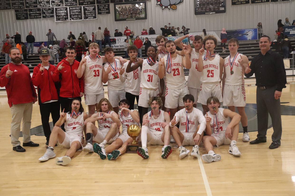 The Prague boys' basketball squad poses with the trophy Saturday after winning the championship of the 66 Conference Tournament.