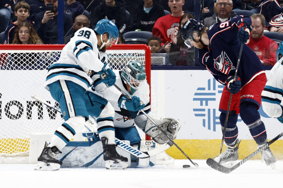 San Jose Sharks goalie Magnus Chrona, center, stops a shot between teammate defenseman Mario Ferraro (38) and Columbus Blue Jackets forward Alexander Nylander during the first period of an NHL hockey game in Columbus, Ohio, Saturday, March 16, 2024. (AP Photo/Paul Vernon)