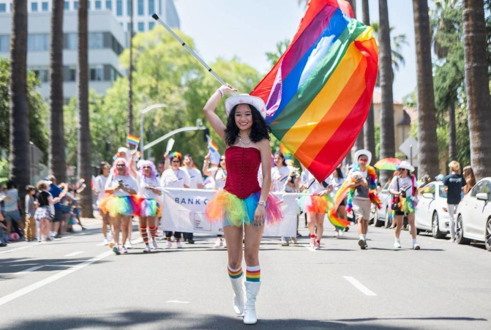 Maxine Yap, 15, twirls a rainbow flag while leading the Bank of America marchers along the Pride March parade route through downtown Sacramento on Sunday. “Everyone’s so cheerful, and it makes me so happy,” Yap said.