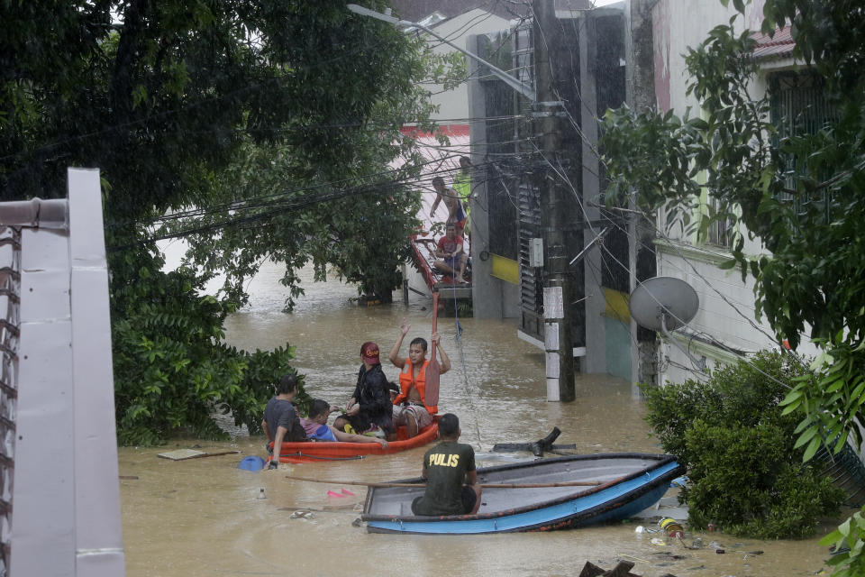 Police rescue residents from their homes as floods continue to rise in Marikina, Philippines, due to Typhoon Vamco on Thursday, Nov. 12, 2020. A typhoon swelled rivers and flooded low-lying areas as it passed over the storm-battered northeast Philippines, where rescuers were deployed early Thursday to help people flee the rising waters.(AP Photo/Aaron Favila)