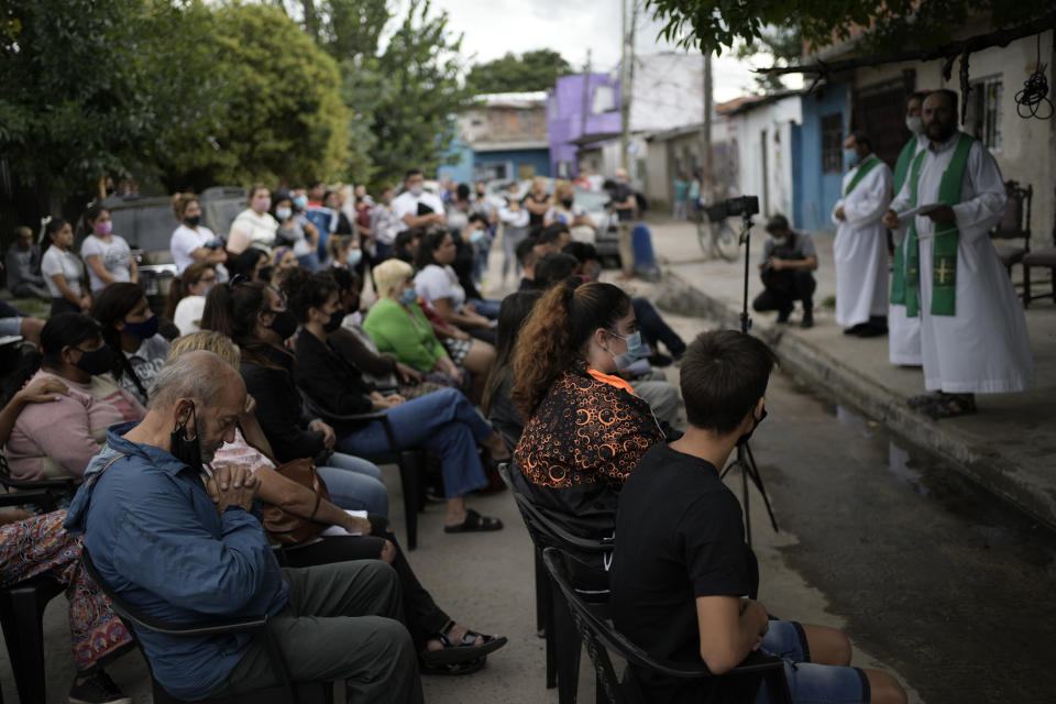 People attend an outdoor Catholic Mass held in remembrance of those who recently died from consuming toxic cocaine and for those who were severely sickened by the contaminated drug, in the Puerta 8 neighborhood, a suburb north of Buenos Aires, Argentina, Saturday, Feb. 5, 2022. A batch of cocaine has killed at least 23 people and hospitalized many more in Argentina, according to police. (AP Photo/Rodrigo Abd)