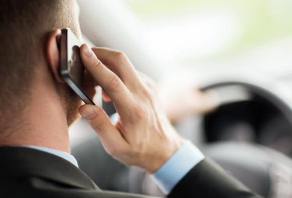 transportation and vehicle concept - man using phone while driving the car