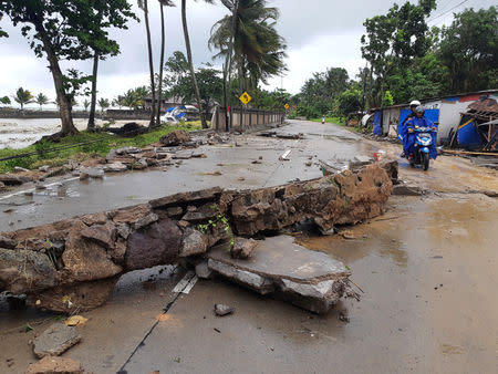 Residents ride a motorcycle past a collapsed wall after a tsunami hit Carita beach in Pandeglang, Banten province, Indonesia, December 23, 2018. REUTERS/Adi Kurniawan