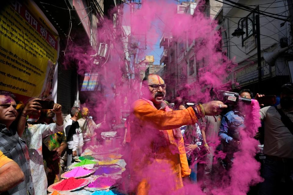 A Hindu man sprays coloured powder as people celebrate Holi, the Hindu festival of colors, in Jammu, India (AP)