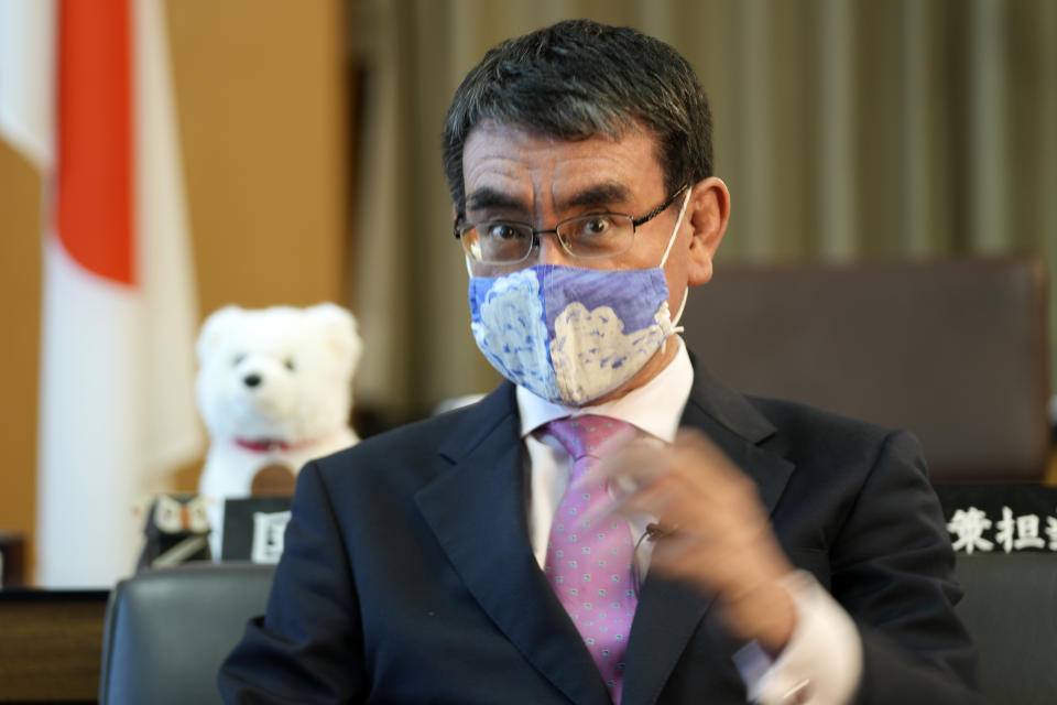 Taro Kono, Japan's minister in charge of a huge vaccination campaign, wearing a face mask speaks during an interview with The Associated Press at his office in Tokyo Wednesday, July 28, 2021. As Olympics host Tokyo saw another record number of coronavirus cases Wednesday, Kono told that the speed of the inoculation campaign, which is averaging about 10 million shots a week after a late start, is less urgent than getting shots to young people, who are blamed for spreading the virus. (AP Photo/Eugene Hoshiko)