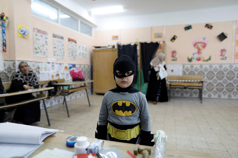 A boy in a Batman costume at a polling station in Algiers