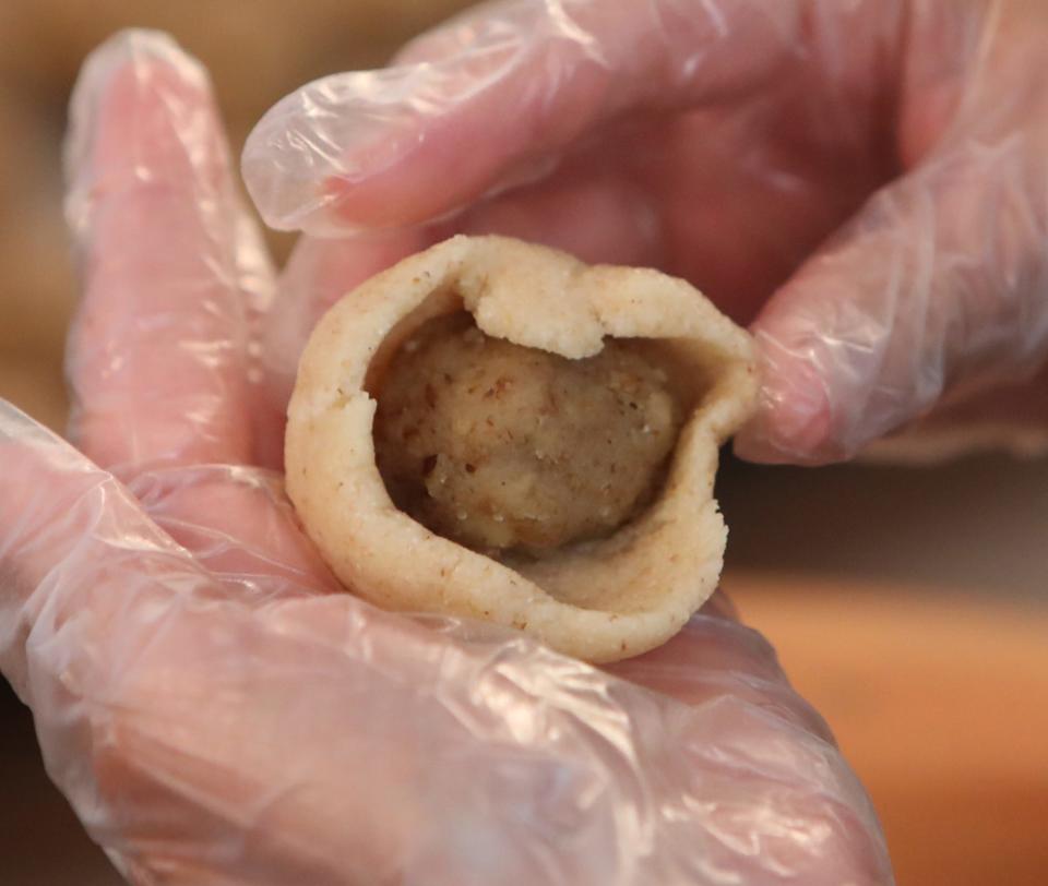 A member of Our Lady of the Cedars prepares a traditional Lebanese ma'mool cookie with a walnut filling July 18.