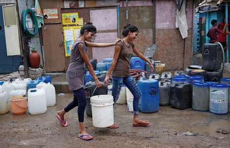 Girls carry a water container after filling it from a municipal tanker in New Delhi, India, June 26, 2018. Picture taken June 26, 2018. REUTERS/Adnan Abidi