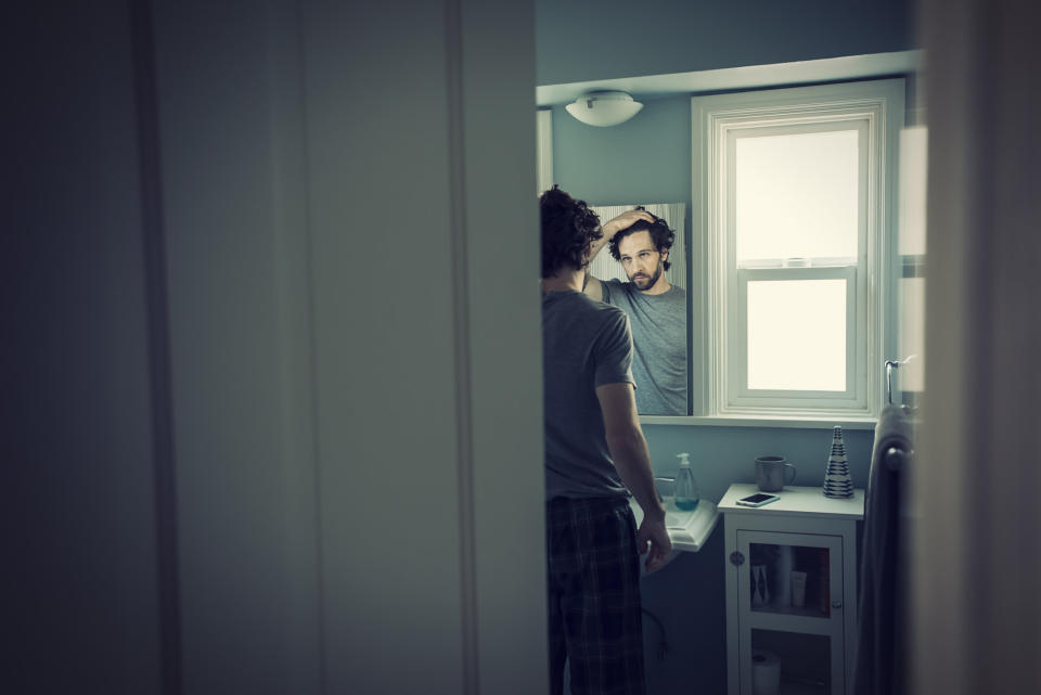 A guy looking at himself in the mirror