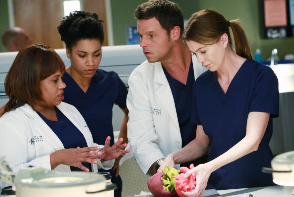 four characters of grey's anatomy huddled and chatting