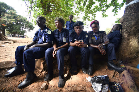 Policemen take a break during a presidential run-off in Freetown, Sierra Leone March 31, 2018. REUTERS/Olivia Acland