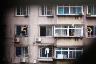 RNPS - PICTURES OF THE YEAR 2013 - A man, whose last name is Hou (L), climbs outside a window with a knife, as his mother (C) and a plain clothes policeman look on, in Anshan, Liaoning province August 26, 2013. Hou held his mother captive in his apartment before climbing out of the window and threatening to cut himself. After several hours, he was controlled by policemen who managed to enter the house from another window with the help of his mother, local media reported. REUTERS/Stringer (CHINA - Tags: SOCIETY TPX) CHINA OUT. NO COMMERCIAL OR EDITORIAL SALES IN CHINA