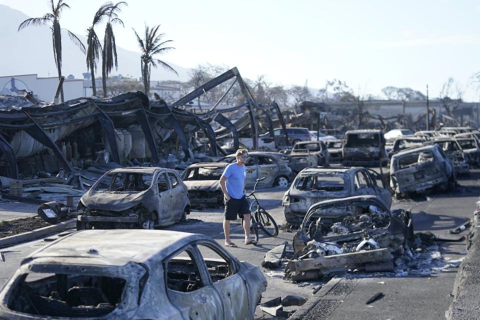 A person walks through a scene of destruction after a wildfire left almost the entire city of Lahaina, Hawaii, in ashes in August 2023. <a href="https://newsroom.ap.org/detail/APTOPIXHawaiiFires/28d53ef953524ec8ba61a0c7ec830881/photo" rel="nofollow noopener" target="_blank" data-ylk="slk:AP Photo/Rick Bowmer;elm:context_link;itc:0;sec:content-canvas" class="link ">AP Photo/Rick Bowmer</a>