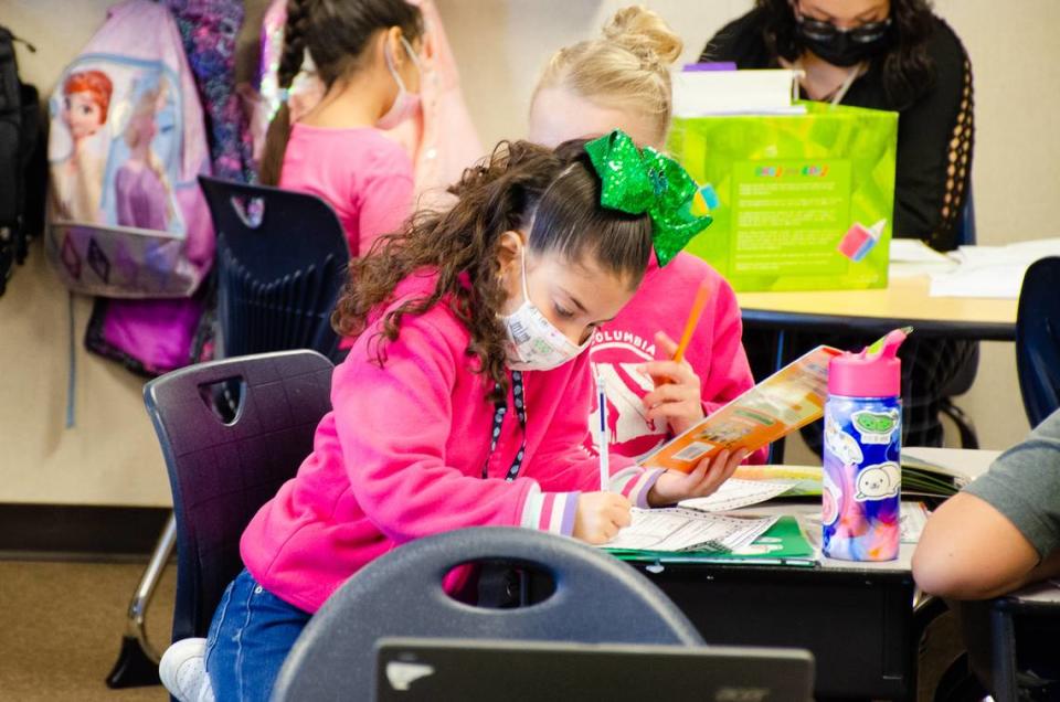 Venessa Miranda, a second-grader at Mark Twain Elementary School, studies a book on animals in a Pasco dual language classroom.